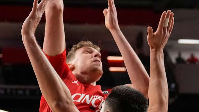 Cincinnati Bearcats forward Viktor Lakhin (30) rises above Texas Longhorns forward Brock Cunningham (30) in the first half of the NCAA Big 12 basketball game between the Cincinnati Bearcats and the Texas Longhorns at Fifth Third Arena in Cincinnati on Tuesday, Jan. 9, 2024.
